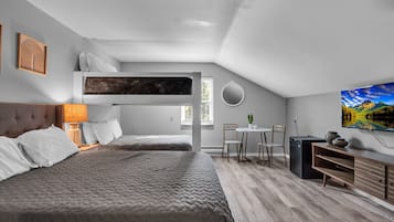 Un dormitorio moderno con una cama nido, un escritorio y una mesa de comedor.