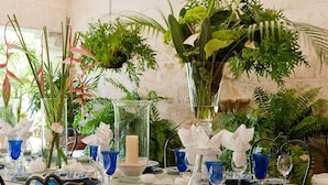 A table set with blue and white patterned plates, blue glassware, and a large vase with green foliage. - Leamington House - Five Bedroom Villa, Sleeps 10 (Little Battaleys)