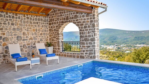 A stone-walled infinity pool with two white lounge chairs and blue cushions, overlooking a scenic landscape. - Villa Kotop - Three Bedroom Villa, Sleeps 6 (Dub, Kotor)