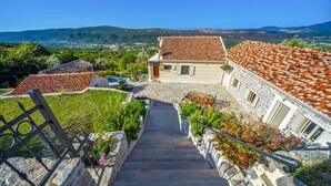 A stone staircase leading to a building with a tiled roof, surrounded by greenery and a view of distant hills. - Villa Kotop - Three Bedroom Villa, Sleeps 6 (Dub, Kotor)