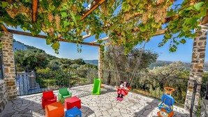A covered outdoor area with a swing set, colorful chairs, and a view of the countryside. - Villa Kotop - Three Bedroom Villa, Sleeps 6 (Dub, Kotor)