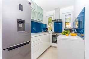 Oppvaskmaskin, høy barnestol og spisebord