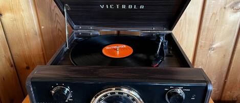 Un tocadiscos Victrola con cubierta de madera y un disco de vinilo adentro.