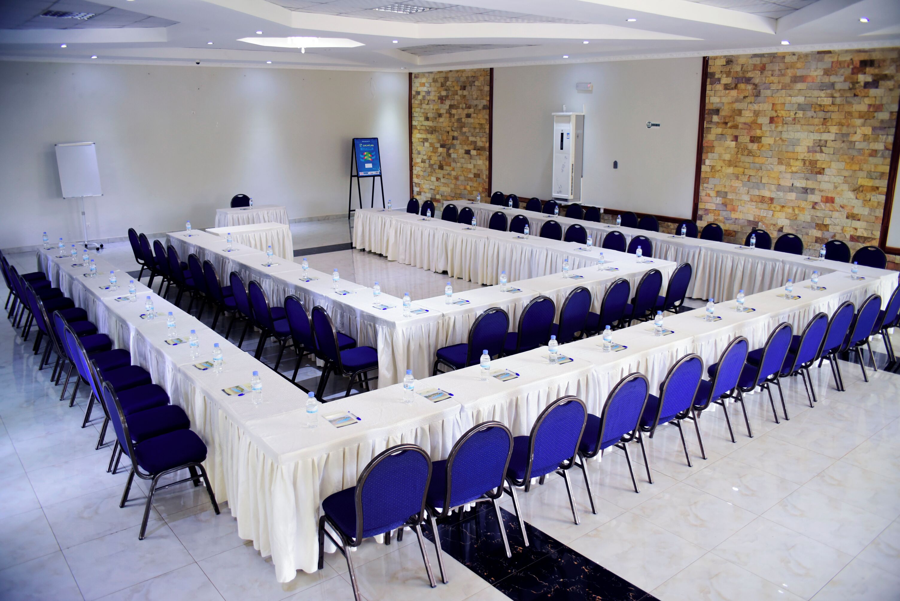A conference room with long tables, chairs, and a whiteboard.