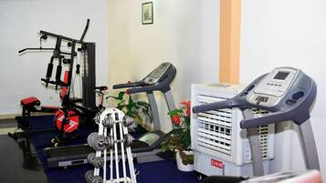 Une salle de sport équipée de matériel d’exercice, d’un tapis de course et d’un vélo d’appartement.