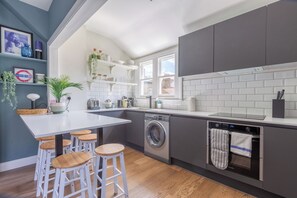 A modern kitchen with a built-in washing machine, a dishwasher, and a stainless steel oven. - Luxurious and Well-Designed 3BD flat, Clapham (London)