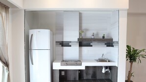 A compact kitchen with a built-in refrigerator, a sink, and a small countertop.