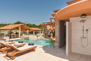 A pool area with lounge chairs, a covered seating area, and a shower. - Villa Klementina - Three Bedroom Villa, Sleeps 6 (Bicine)