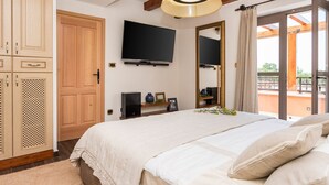 A bedroom with a bed, a TV, a wardrobe, and a balcony with a view. - Villa Klementina - Three Bedroom Villa, Sleeps 6 (Bicine)