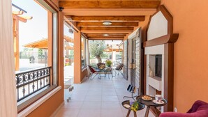 A corridor with wooden beams, a balcony with a metal railing, and a table with chairs. - Villa Klementina - Three Bedroom Villa, Sleeps 6 (Bicine)