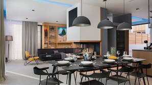 Un comedor moderno con una larga mesa dispuesta para una comida, rodeada de sillas negras.