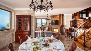 A dining area with a round table set for a meal, a wooden cabinet, and a fireplace.