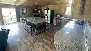 A spacious kitchen with granite countertops, a large island, and a stone fireplace. - Crestview-Spectacular 3 bed 3 bath 5 min to slopes (Banner Elk)