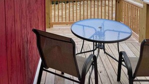 A wooden deck with a round table and two chairs, overlooking a mountainous landscape. - Crestview-Spectacular 3 bed 3 bath 5 min to slopes (Banner Elk)