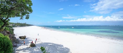 Na praia, espreguiçadeiras, toalhas de praia 