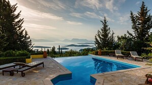 Ein Schwimmbecken mit Liegestühlen und Blick auf die Berge.