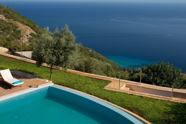 A swimming pool with a view of the sea, surrounded by greenery and a wooden deck. - Villa Kato - Three Bedroom Villa, Sleeps 8 (Lefkada)