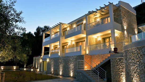 A modern multi-story building with stone facade, balconies, and a staircase leading to the upper levels. - Villa Ipsos - Five Bedroom Villa, Sleeps 9 (Spartilas)