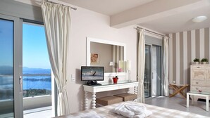 A bedroom with a bed, a desk, a TV, and a view of the sea. - Villa Ipsos - Five Bedroom Villa, Sleeps 9 (Spartilas)
