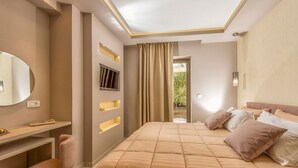 Ein Schlafzimmer mit einem großen Bett, einem Schreibtisch, einem Stuhl, einem Spiegel und einem Fenster mit Vorhängen.