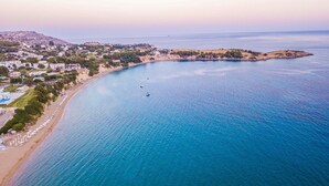 Vista aérea de una zona costera con playa, barcos y edificios.