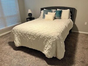 Cozy retreat with a comfortable bed, reading table, and natural light.