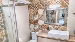 Ein Badezimmer mit Dusche, Toilette und Waschbecken.