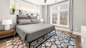 A bedroom with a bed, bedside lamps, a ceiling fan, a window with blinds, and a wall-mounted plant.