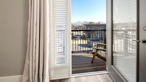 A balcony with a view of a parking lot and buildings.