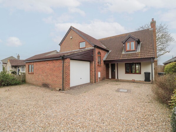 A two-story house with a gravel driveway, a garage, and a small garden area. - Morgan House (Bridgwater)