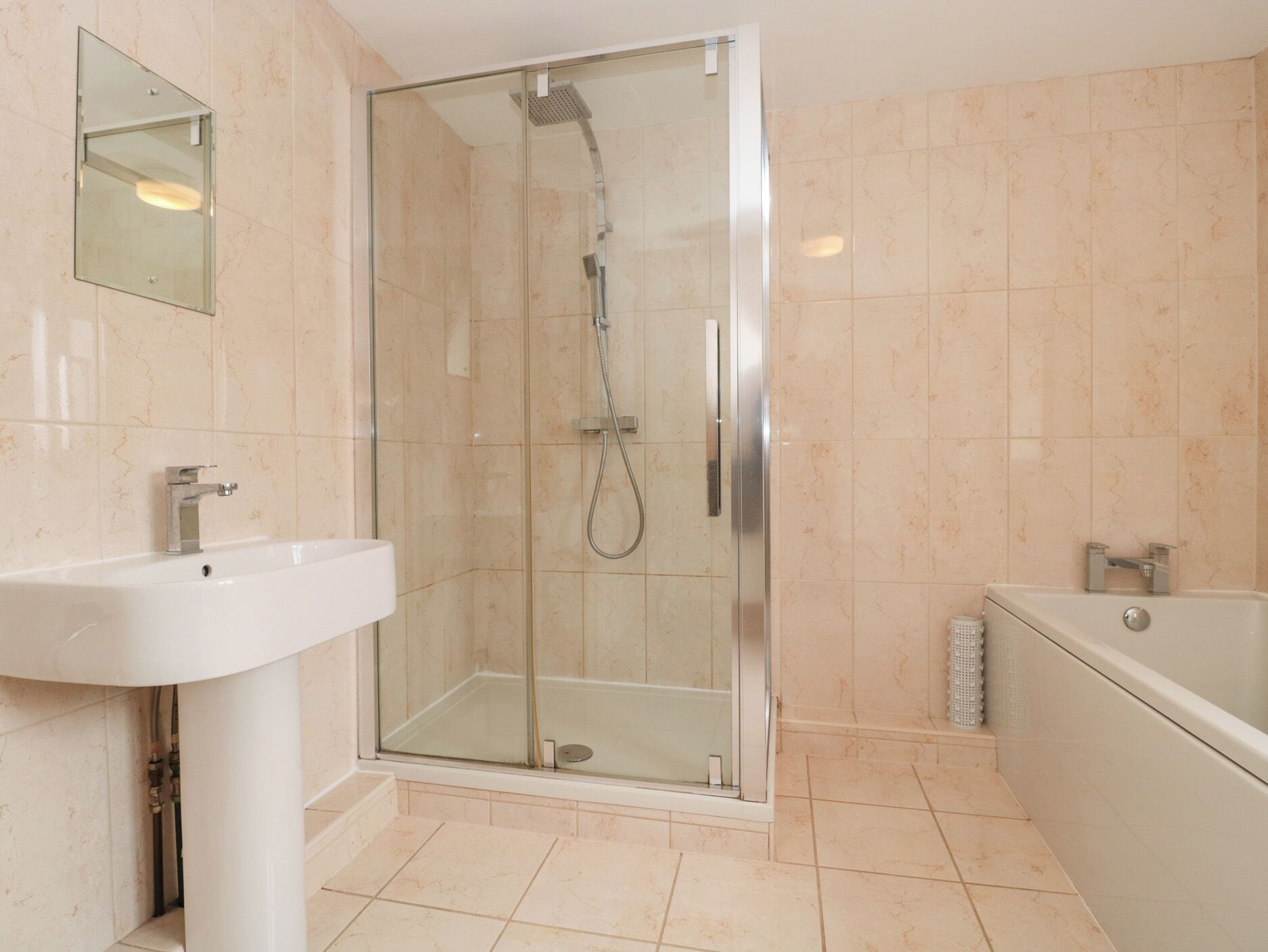 A modern bathroom with a glass-enclosed shower, a white sink, and a bathtub.