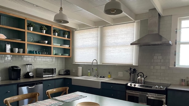 A modern kitchen with a central island, built-in shelves, a large window, and a stove. - Old Town “Secret Chef”,  near Historic Downtown Saint Augustine (St. Augustine)