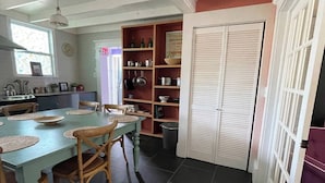 A kitchen with a dining table, chairs, and a built-in shelf with kitchenware. - Old Town “Secret Chef”,  near Historic Downtown Saint Augustine (St. Augustine)