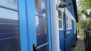 A blue house with a front door, a small porch, and a brick pathway leading to the entrance. - Old Town “Secret Chef”,  near Historic Downtown Saint Augustine (St. Augustine)