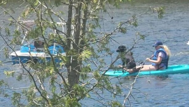 Two people on a small boat in a calm body of water. - 10) The RV Campsite 6 (Stewartstown)