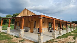 Un edificio de estilo granero de madera con un porche cubierto y pilares de piedra.