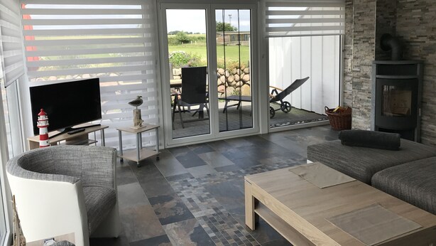 A modern living room with a TV, seating, and a fireplace.