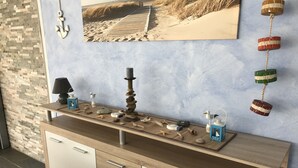 A wooden console table with decorative items, a lamp, and a small bird figurine.