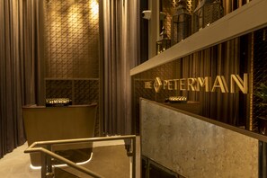 A modern interior with a reception desk, a patterned wall, and a sign reading "The Peterman". - Forty Seven Hotel Manchester, WorldHotels Crafted (Manchester)