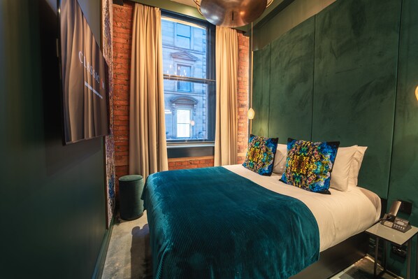 A modern hotel room with a large bed, green walls, and a view of a building through a window with curtains. - Forty Seven Hotel Manchester, WorldHotels Crafted (Manchester)