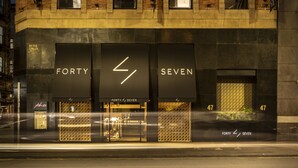 Une façade d’immeuble avec une grande enseigne indiquant « Forty Seven » et une adresse bien visible, le numéro « 47 ».