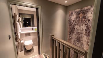 A modern bathroom with a toilet, sink, and towel rack.