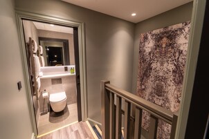 Un baño moderno con inodoro, lavamanos y toallero.