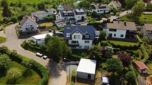 A residential area with houses, a winding road, and green fields.