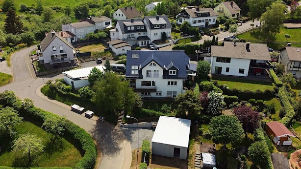 A residential area with houses, a winding road, and green fields. - Vacation apartment Maar-Idyll, quiet, modern vacation apartment with freedom of movement (Schalkenmehren)
