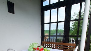 A table set for a meal with a view of the outdoors. - Vacation apartment Maar-Idyll, quiet, modern vacation apartment with freedom of movement (Schalkenmehren)