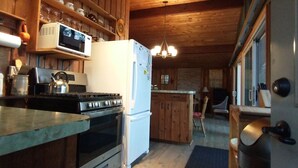 A kitchen with wooden cabinets, a microwave, a refrigerator, an oven, and a sink.