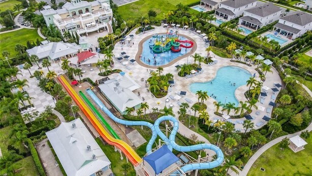 Luftaufnahme eines Resorts mit Wasserpark, einschließlich Rutschen und Pools, umgeben von üppiger Vegetation und Gästeunterkünften.