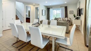 Ein modernes Wohnzimmer mit Essbereich, einer Treppe und Blick ins Freie.