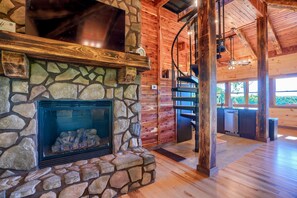 Une cheminée en pierre avec un manteau en bois, un mur en pierre et un plafond en bois.